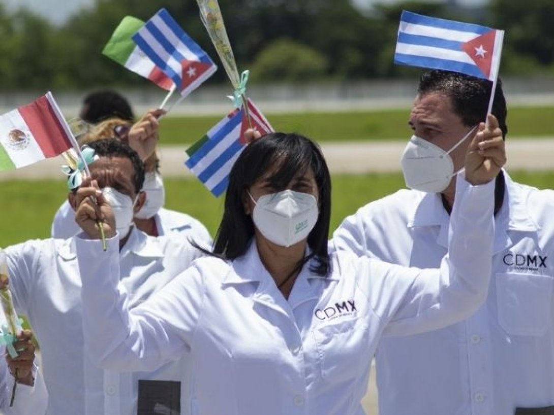 Médicos cubanos en México levantan banderas de Cuba y México como parte de su misión sanitaria.