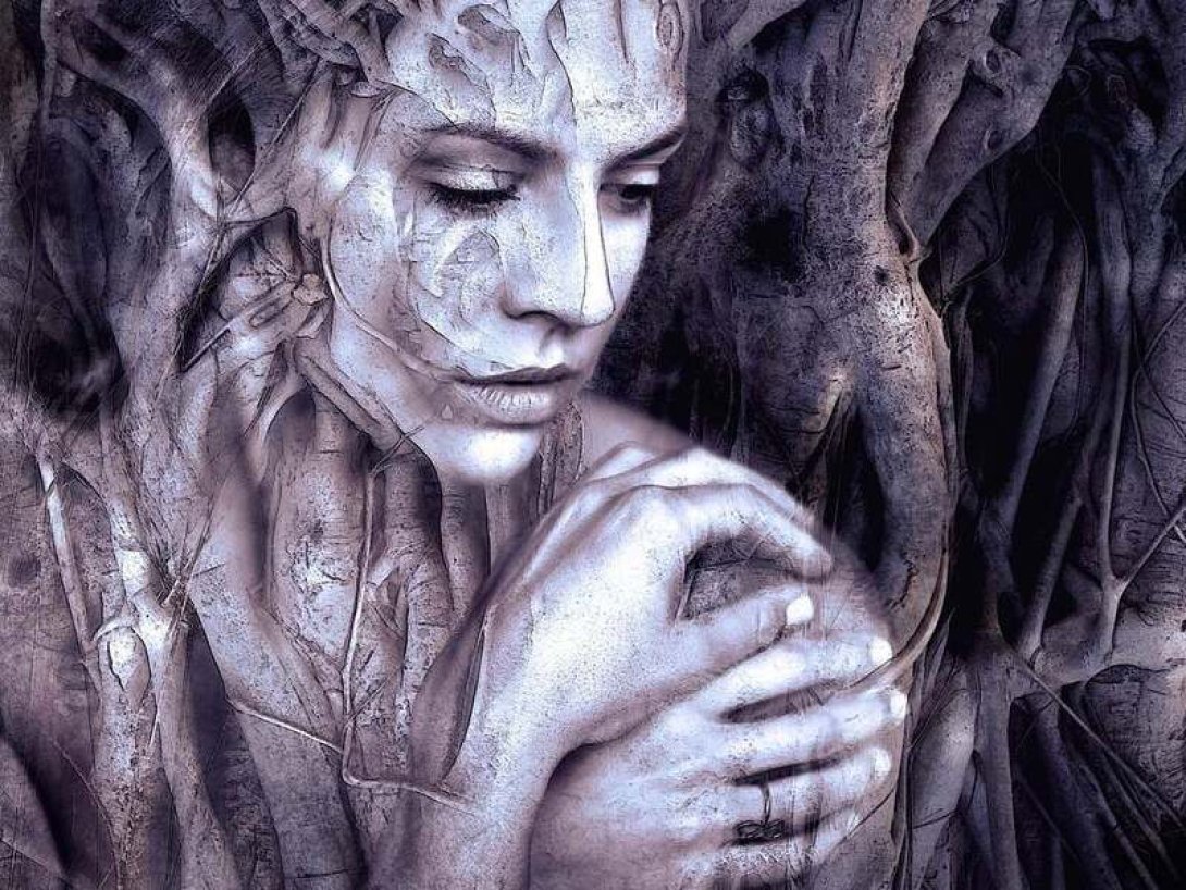 Cuerpo femenino entre las ramas de un árbol.