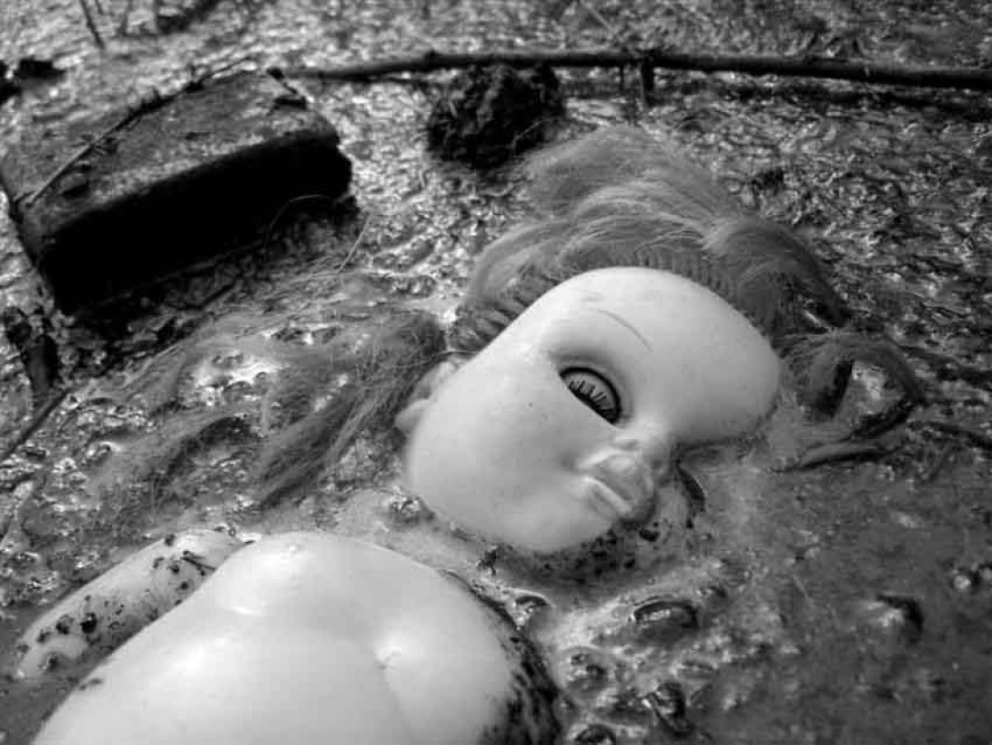 Muñeca hundida en el fango