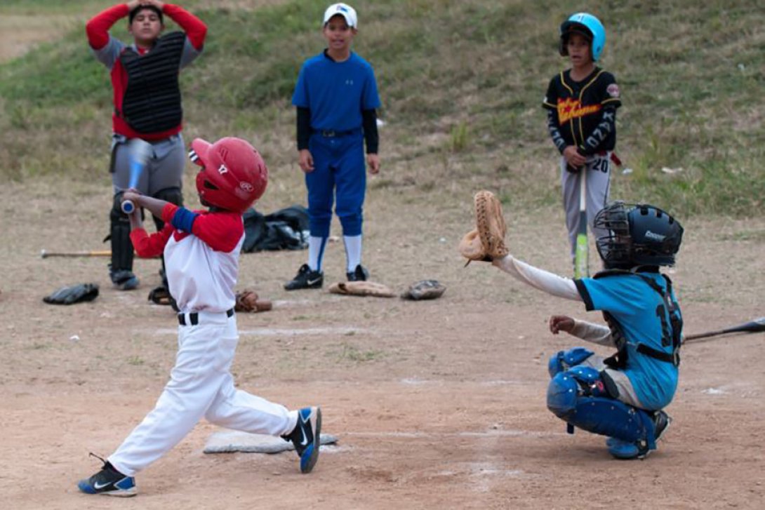 Niños jugando béisbol en el campo en Cuba.