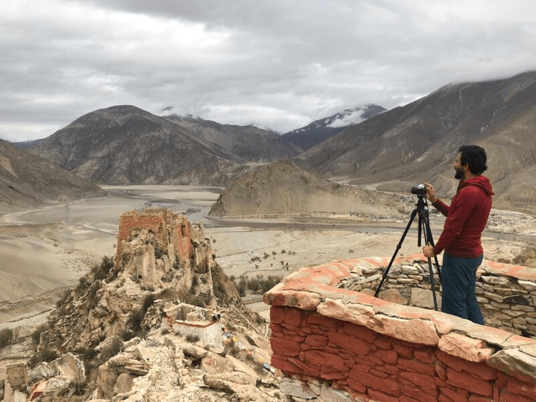 Alejandro Campins con una cámara fotorafía el paisaje del Tíbet, 2019.