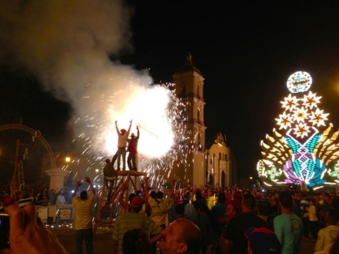 Fuegos artificiales estallan junto a una carroza en las Parrandas de Chambas.