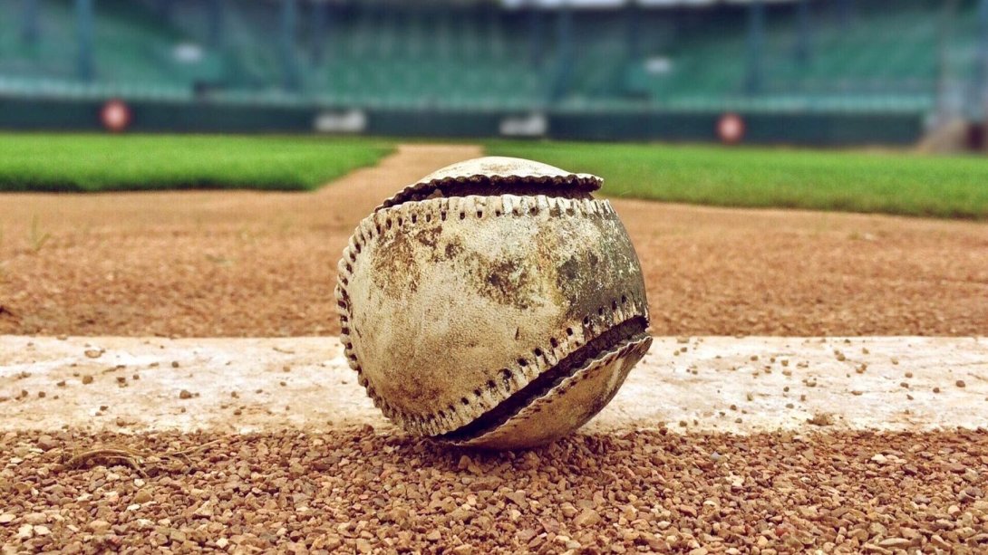 Pelota de béisbol deteriorada en un terreno