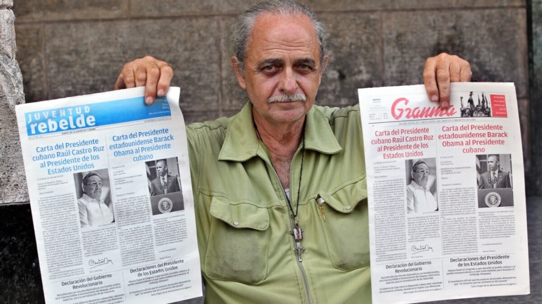 Ciudadano cubano sostiene un periódico Granma y otro Juventud Rebelde