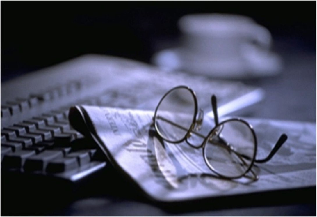 Gafas encima de periódico y teclado. periodismo digital