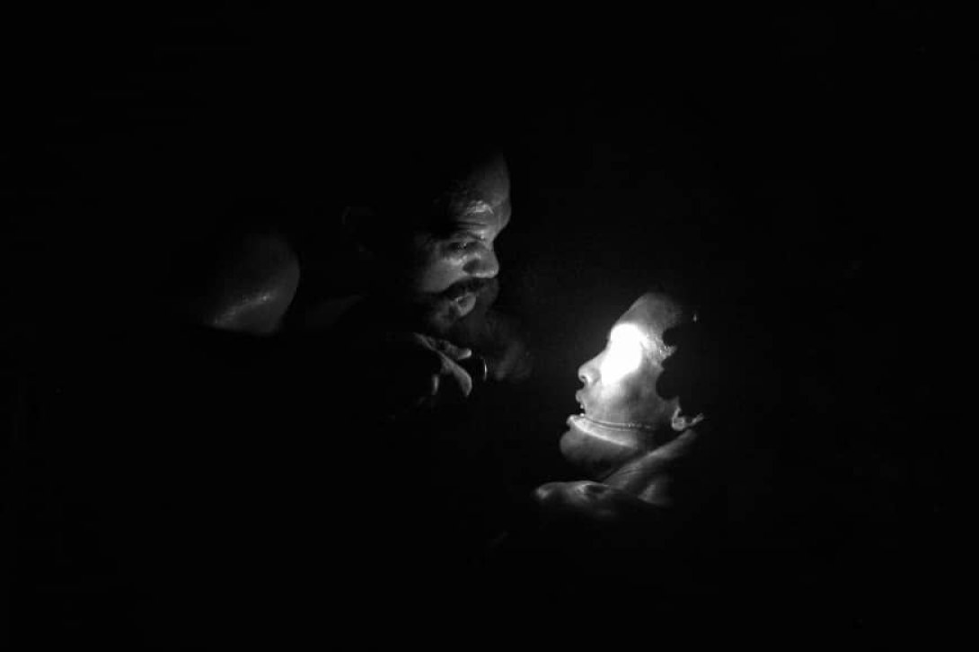 Actores de Perséone Teatro en medio de un escenario a oscuras.