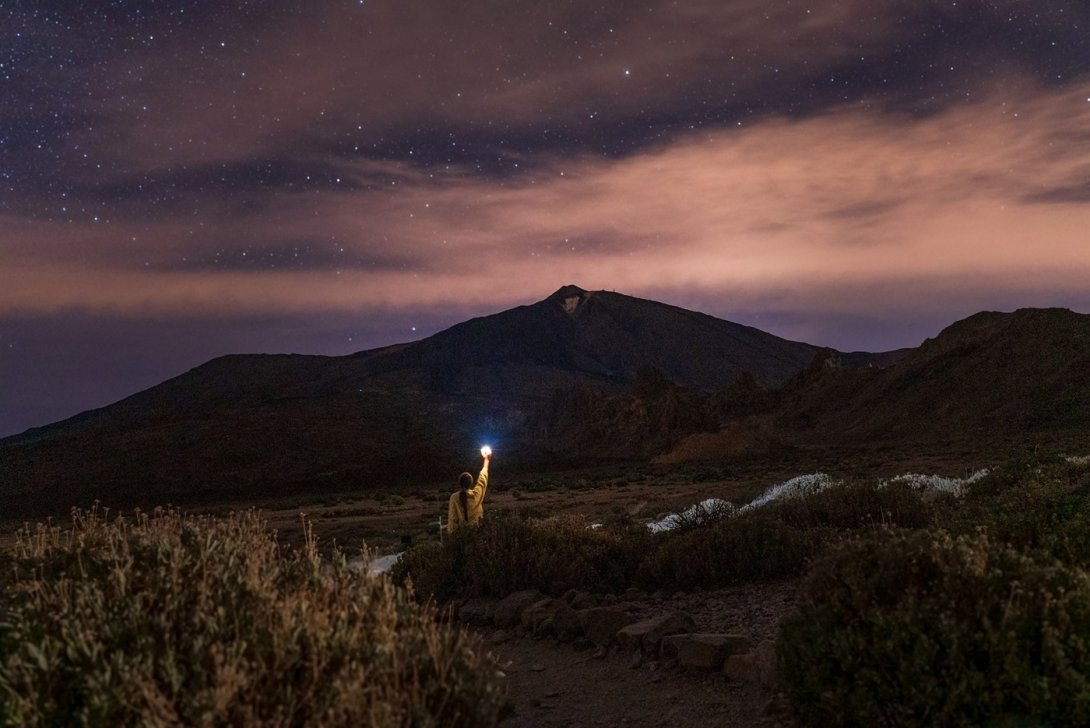 Persona observando el cielo estrellado en un paraje apartado.