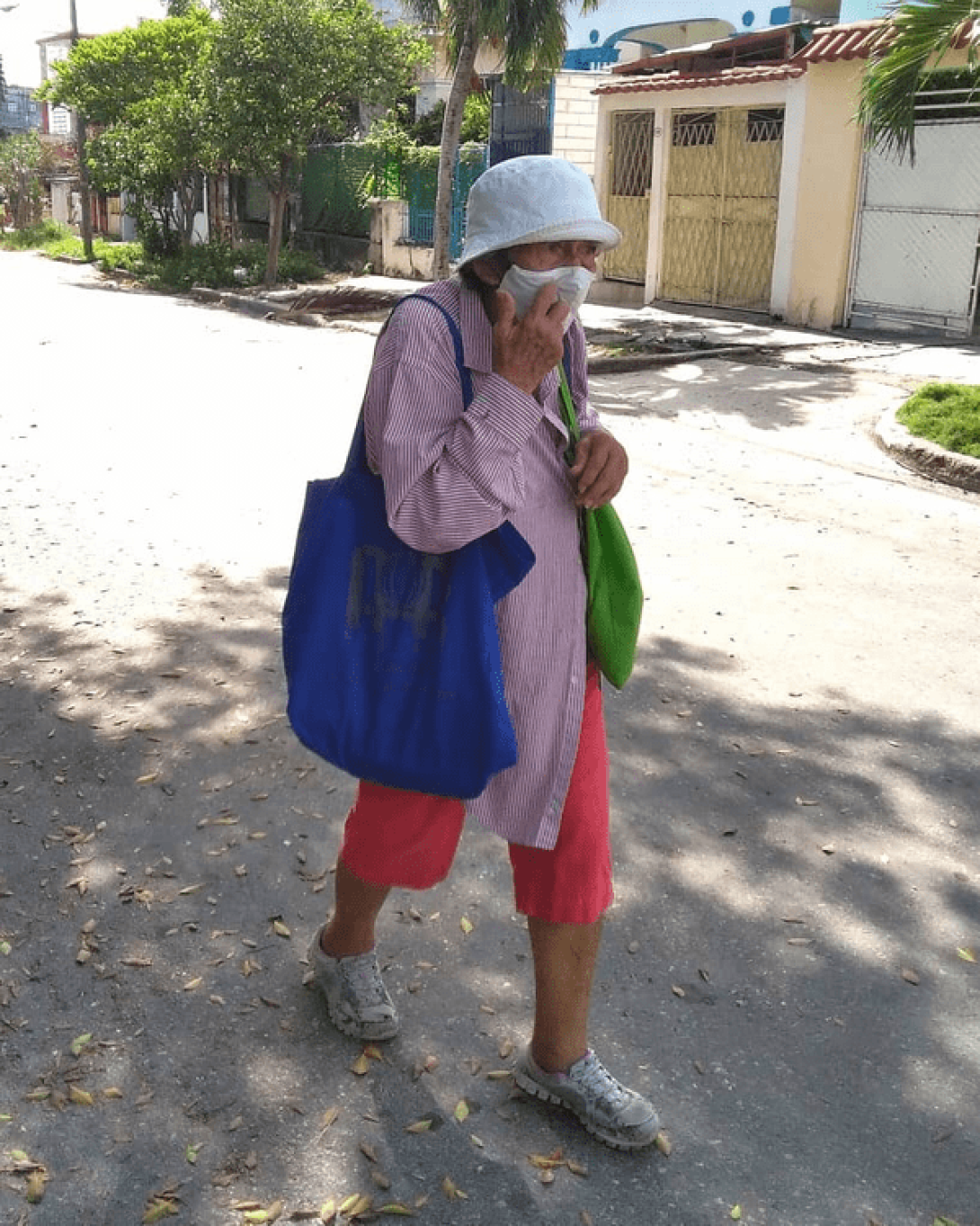Una anciana camina por las calles cubanas llevando bolsas.
