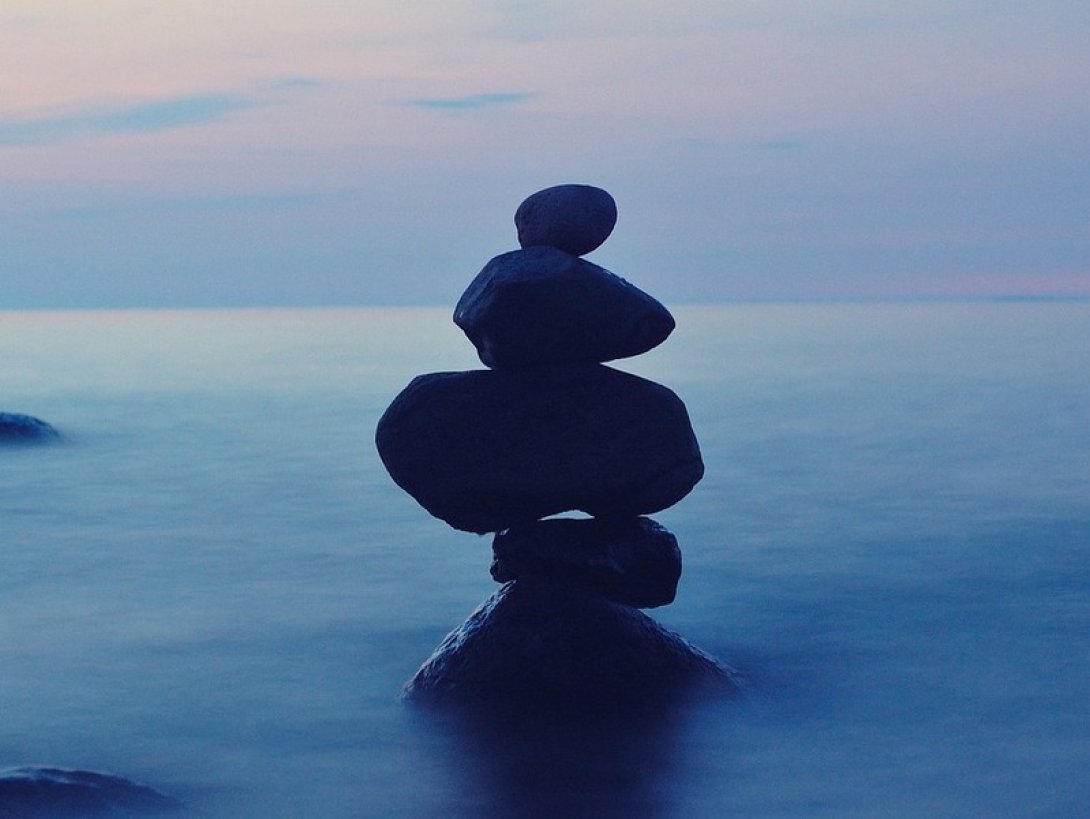 Piedras una encima de otra sobre el agua en la bruma de la noche.