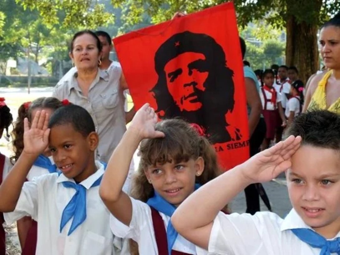 Pioneros cubanos alrededor de una imagen de Ernesto Che Guevara.