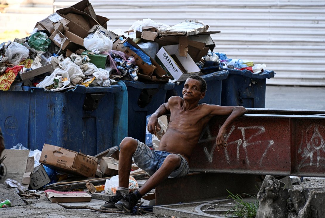Cubano junto a un basurero en la isla. Foto: AFP