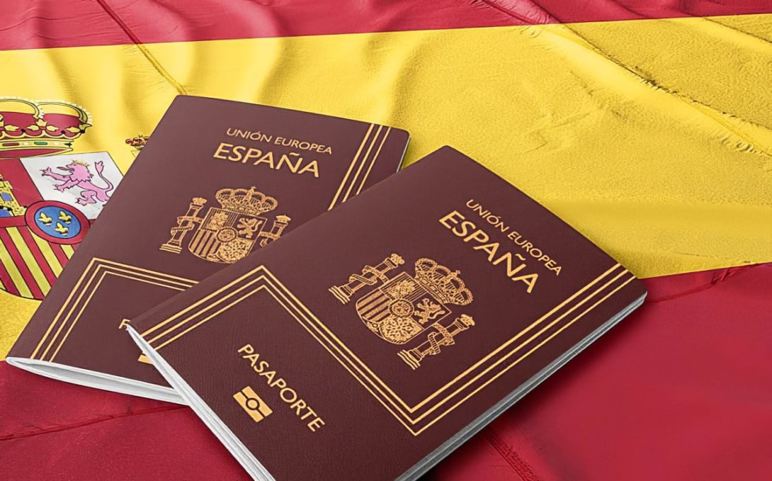dos pasaportes españoles encima de una bandera española.
