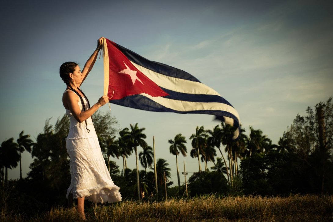 La artista Nany sostiene la bandera cubana mientras ondea