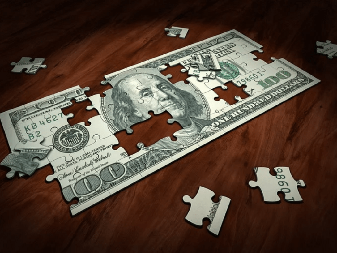 Puzle hecho de un billete de 100 dólares.