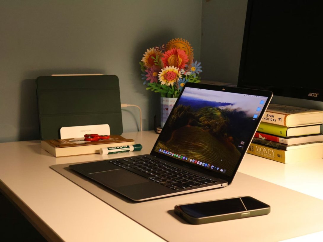 Mesa de redacción de Árbol Invertido con laptop y flores