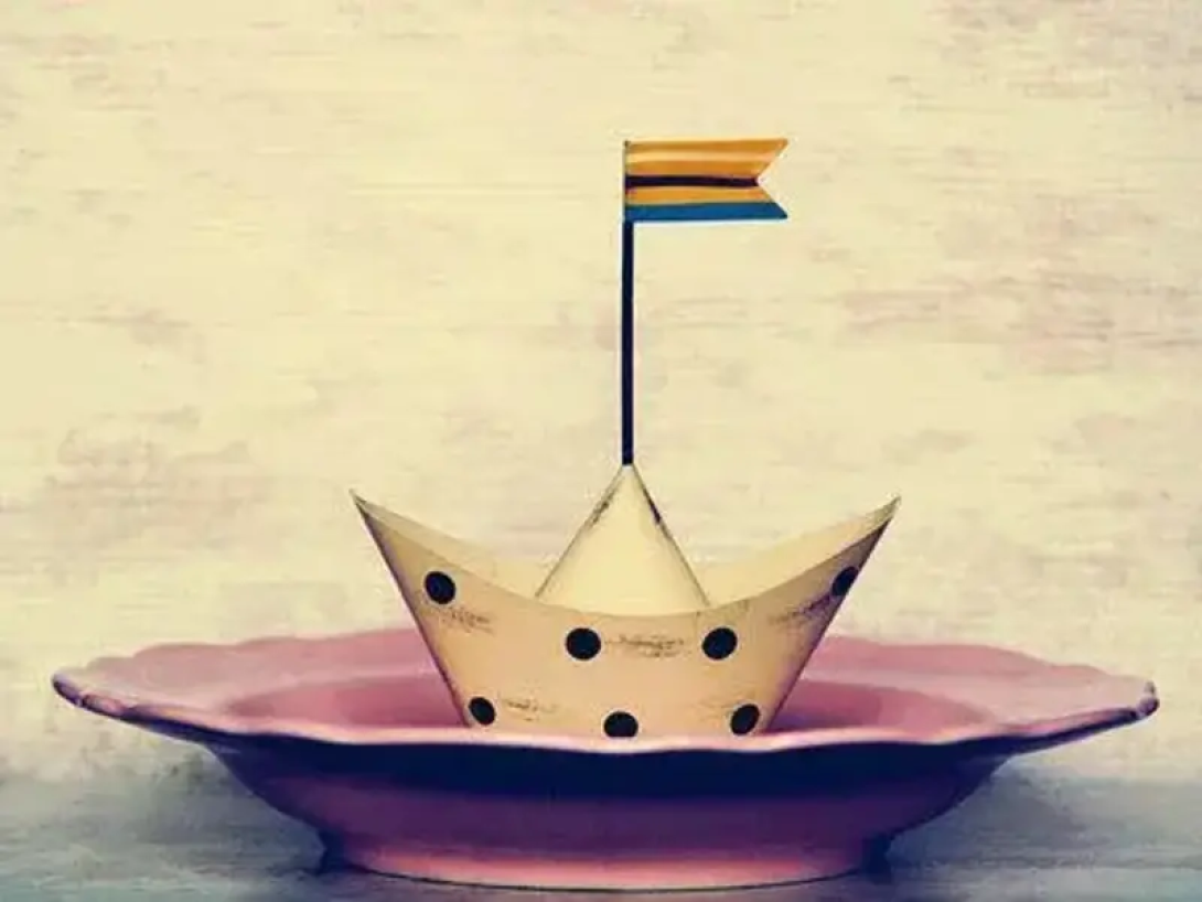 Barco de papel sobre un plato.