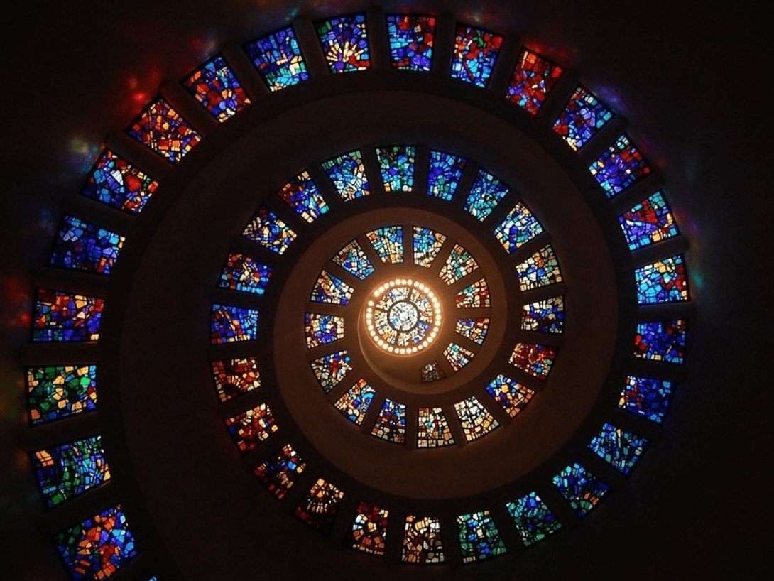 Cristales con vitrales a través de los que entra la luz forman en conjunto una espiral.