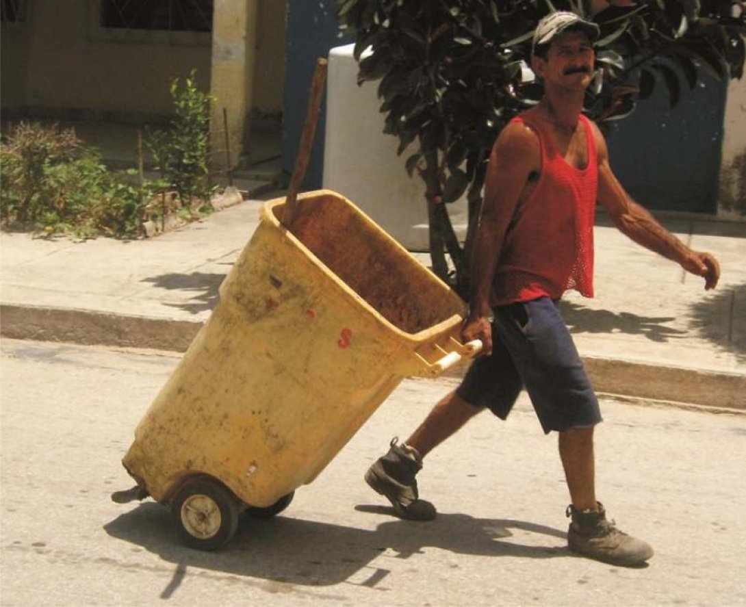 Trabajador de servicios comunales arrastra un tanque. Foto: Francis Sánchez