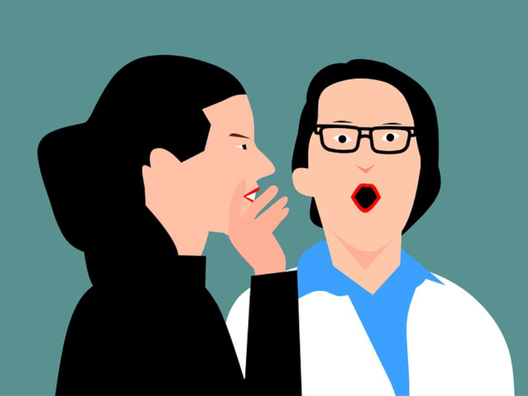 Una persona cuenta un chisme al oído de otra persona que parece asombrada.