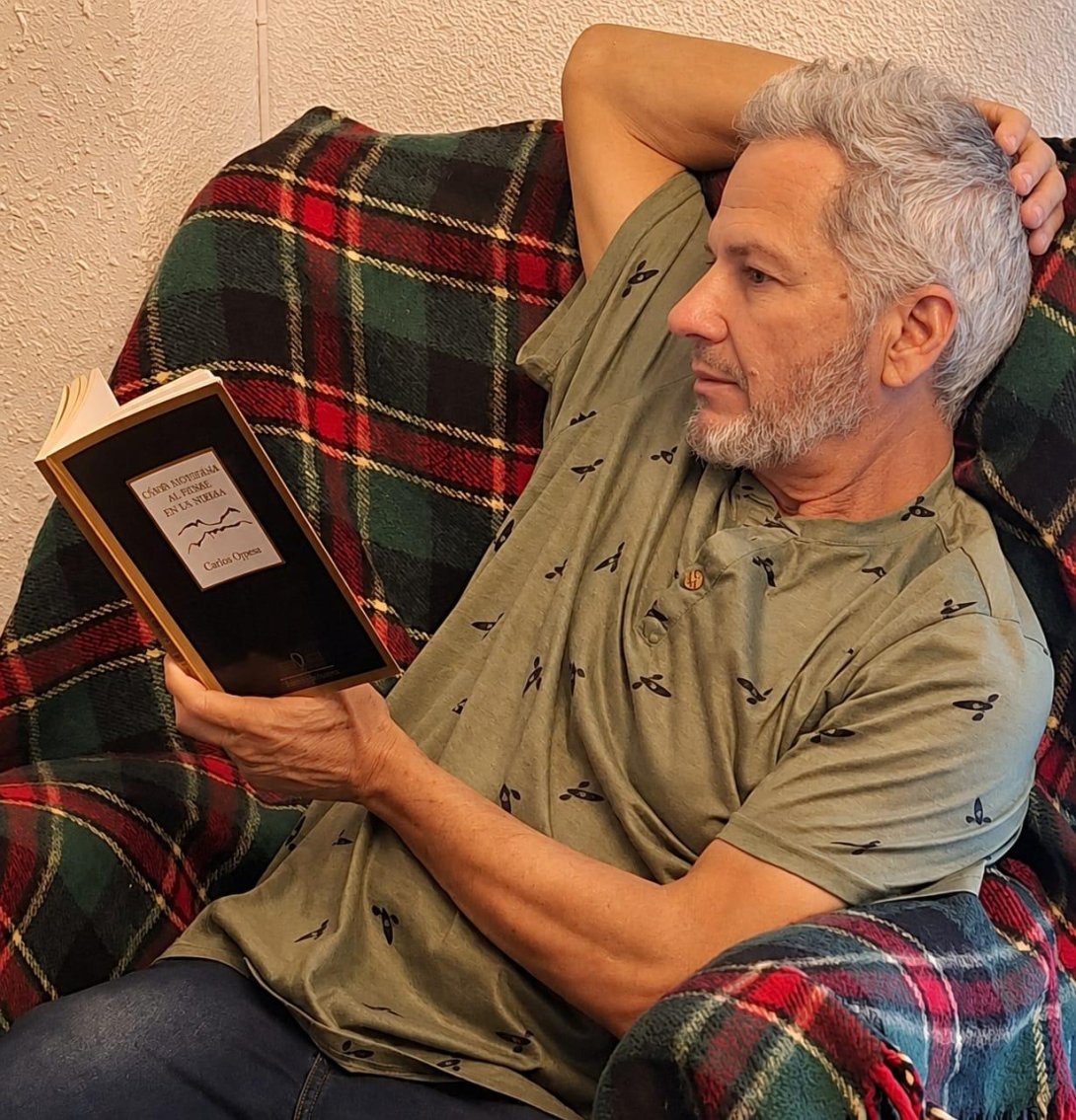 Rafael Vilches leyendo el libro "Cómo enterrar al padre en un poema" (2025) de Corina Oproae. Foto de Ana Rosa Díaz Naranjo.