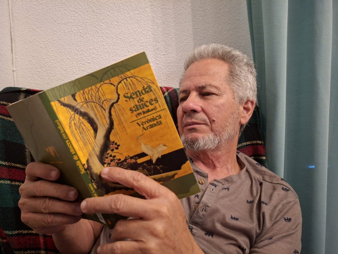 El poeta, artista visual y crítico cubano Rafael Vilches leyendo el poemario "Senda de sauces" (2011) de Verónica Aranda. Foto de Ana Rosa Díaz Naranjo.
