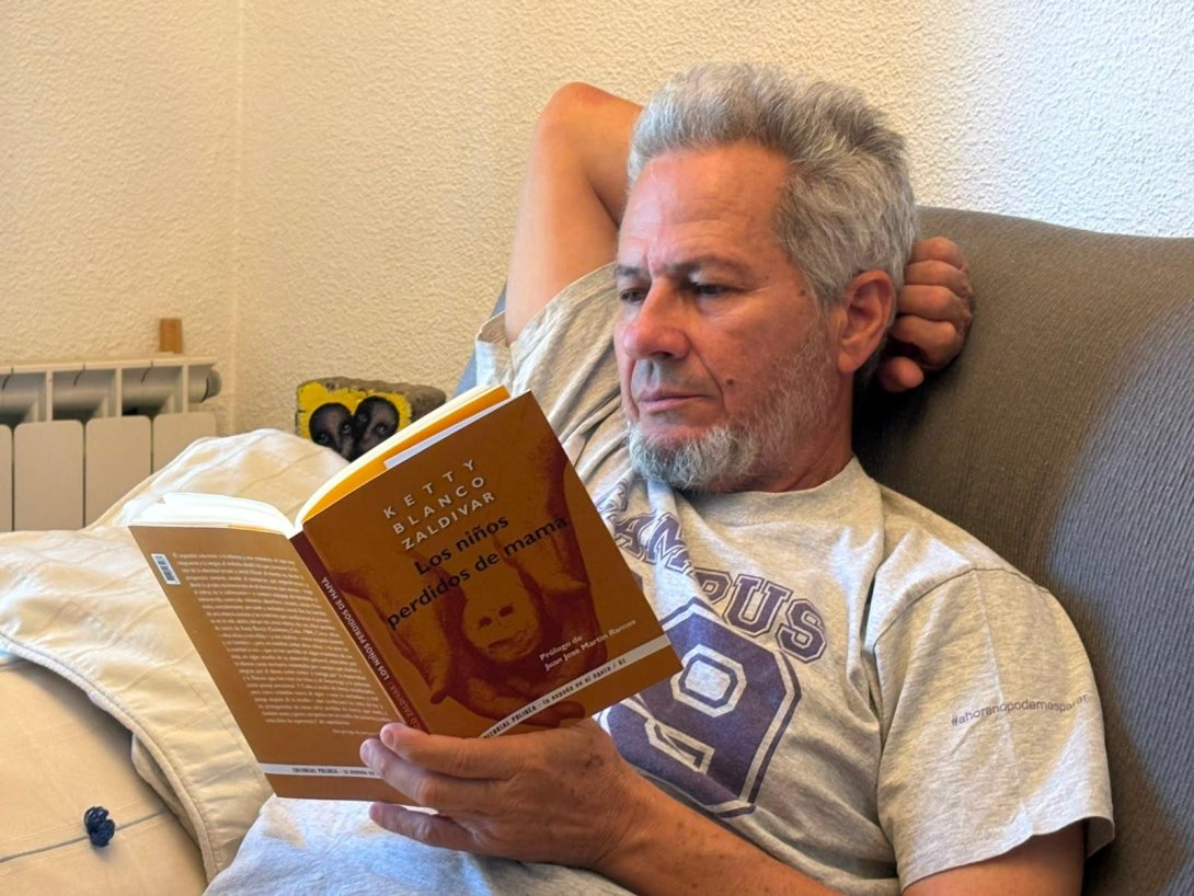 El poeta, artista visual y crítico cubano Rafael Vilches leyendo el libro "Los niños perdidos de mamá" de Ketty Blanco Zaldívar. Foto de Brian J. Vilche Gallardo.