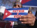 Cubana sosteniendo una bandera cubana con el lema "Patria y Vida".