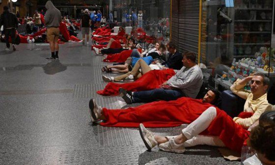 Viajeros preparándose para pasar la noche en la estación de tren de Córdoba.