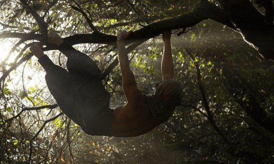 Hudden, creador de "Tarzan Movement" colgado de un árbol.