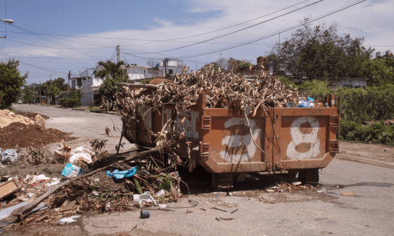 Contenedor de basura desbordado de desperdicios en la calle.