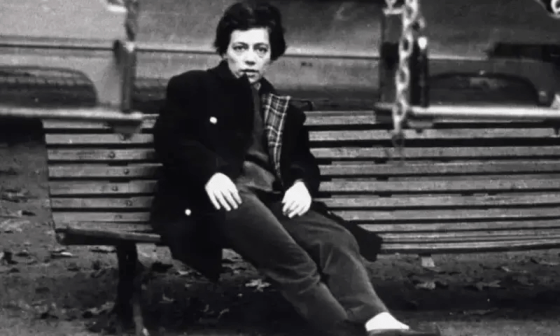 Retrato de Alejandra Pizarnik sentada en un banco.
