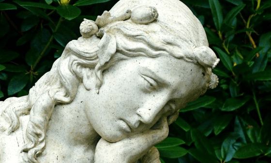 Rostro de una escultura de mujer-ángel pensativa.