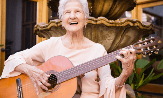 Ángela Álvarez sosteniendo su guitarra y sonriendo.