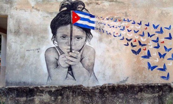 Obra de Maisel López en una calle de La Habana, niña sosteniendo una bandera cubana