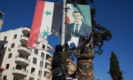 Rebeldes destruyen carteles de Bashar al-Assad.