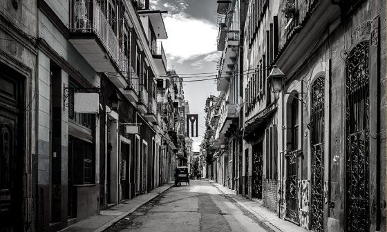 Calle en Cuba con una bandera cubana colgada al centro.