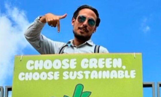 El diseñador cubano Claudio Sotolongo junto su cartel ganador en el evento Anfachen VII, en Hamburgo, Alemania (2023).