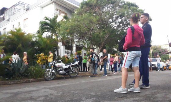 Personas esperando en una larga fila (o cola) en Cuba.