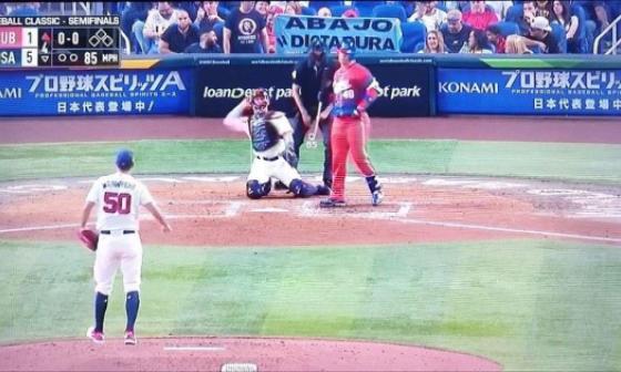 Un cubano muestra un cartel contra la dictadura detrás del home plate.