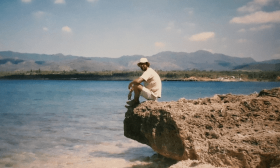 Amilkar sentado sobre una piedra en la bahía de La Boca, en Trinidad, Cuba.