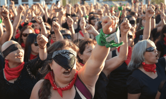 Feministas latinoamericanas protestando con pañuelos negros y verdes y levantando puños.
