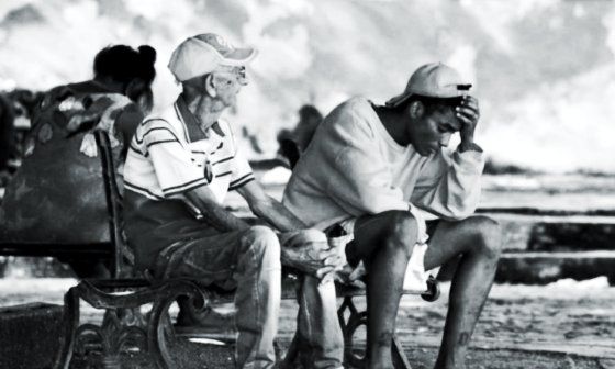 Cubanos sentados en un parque.