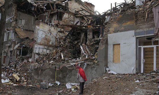 Una anciana observa el estado destruido de un edificio en Ucrania