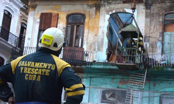 Un miembro de la brigada de rescatistas observa el edificio derrumbado.