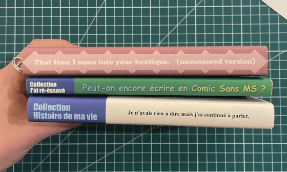 Tres libros, sostenidos por una mano, muestran sus lomos.