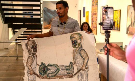 Luis Manuel Otero Alcántara mostrando una obra creada en la prisión política en Cuba, en el Espacio 23, Miami (11 de agosto de 2026). Foto: Luis Eligio D'Omni.