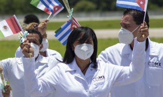 Médicos cubanos en México levantan banderas de Cuba y México como parte de su misión sanitaria.