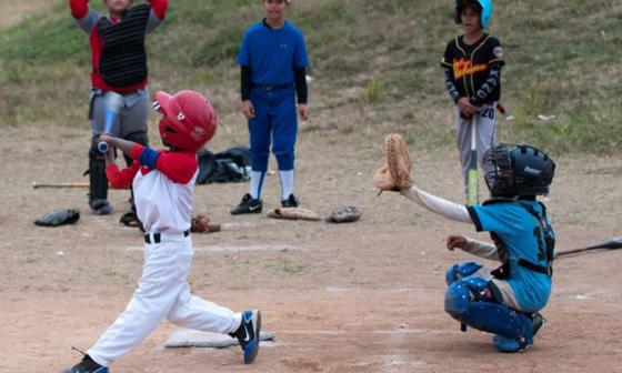 Niños jugando béisbol en el campo en Cuba.