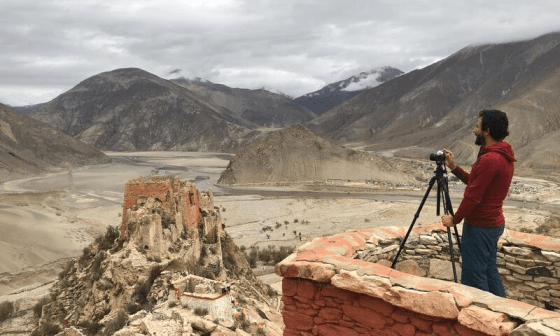 Alejandro Campins con una cámara fotorafía el paisaje del Tíbet, 2019.