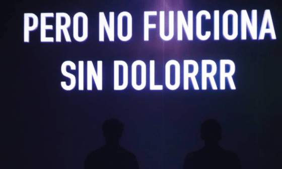 Cartel proyectado en el teatro sobre dos actores: "Pero no funciona sin dolorrr", durante la puesta en escena de "Normalización".